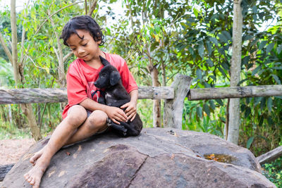 Girl in rural thailand cuddling a dog along the road teasing each other dog cute
