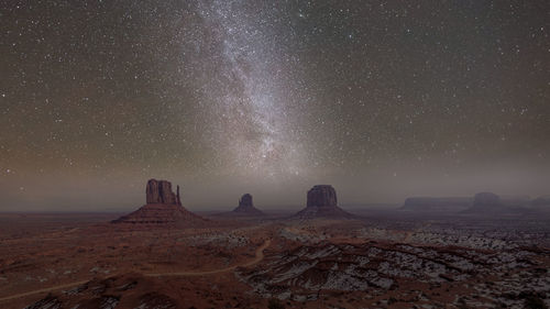 Aerial view of arid landscape against starry field at night
