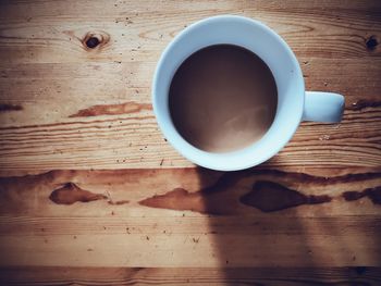 High angle view of coffee cup on wooden table