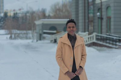 Young african american in winter against the backdrop of a majestic building