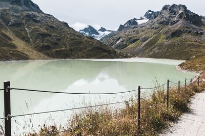 Scenic view of lake by mountains against sky