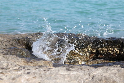 Close-up of wave splashing on rock at beach