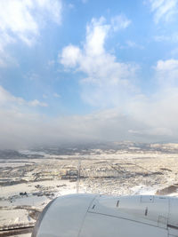 Aerial view of airplane wing against sky