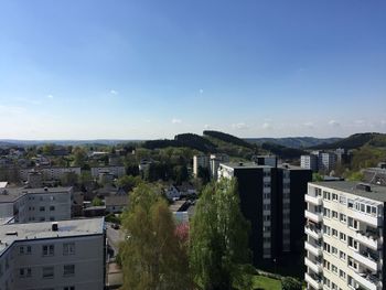 High angle view of residential district against blue sky