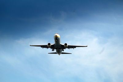 Low angle view of airplane flying against sky
