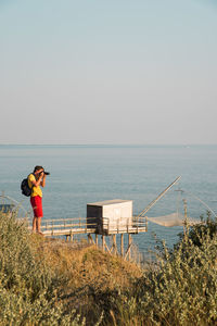 Man standing on beach against clear sky