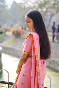 Woman looking away while standing outdoors