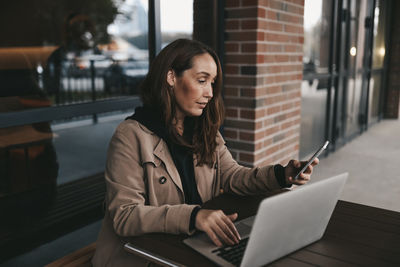 Young woman using mobile phone in office