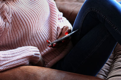 Midsection of woman holding mobile phone