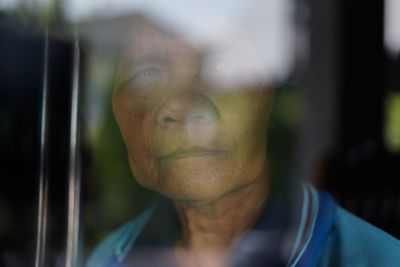 Portrait of woman seen through window