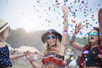 Friends dancing among confetti at the music festival