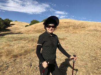 Portrait of young woman wearing sunglasses standing on grassy field at garin regional park