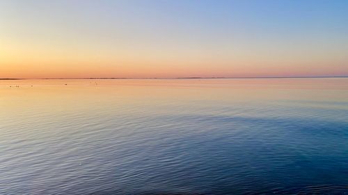 Scenic view of sea against clear sky at sunset
