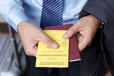 Midsection of man holding paper with text