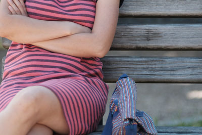 Midsection of woman sitting on bench