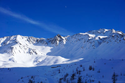 Scenic view of snowcapped mountains against blue sky