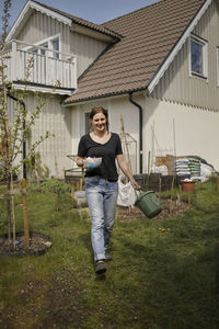 Woman with compost bucket in backyard