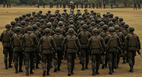 Brazilian army soldiers in formation and marching, facing backwards, equipped for battle