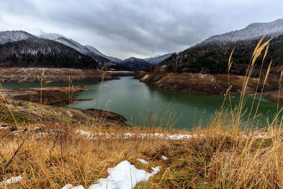 Scenic view of lake against cloudy sky