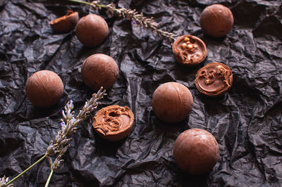 Chocolate round candies on dark crumpled craft paper with lavender flowers