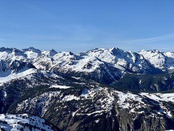 Scenic view of snowcapped mountains against blue sky