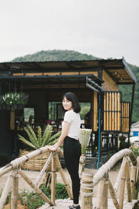 Portrait of woman standing against built structure