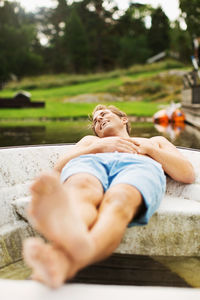 Full length of happy mature man relaxing in boat