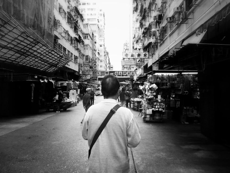 building exterior, architecture, built structure, rear view, street, city, men, walking, city life, lifestyles, residential structure, full length, casual clothing, residential building, person, market, incidental people, building