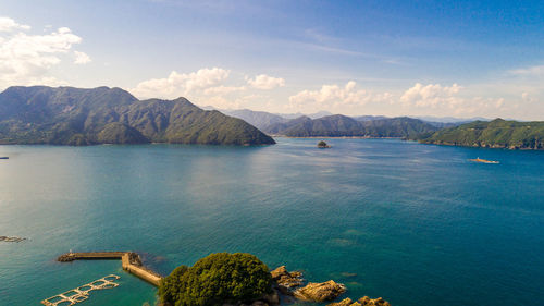 Scenic view of sea and mountains against sky