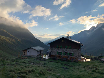 Houses by buildings against sky