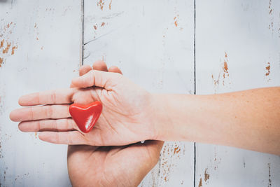 Cropped hands with heart shape decoration on table