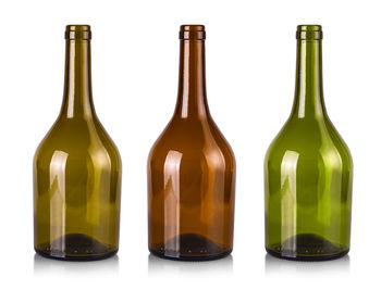 Close-up of glass bottles against white background