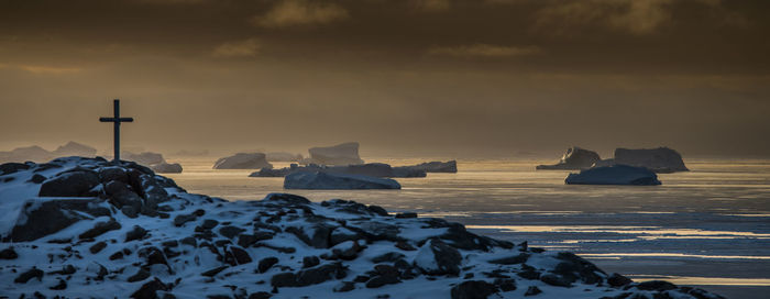 Scenic view of frozen sea against sky during sunset