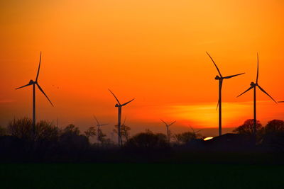 Scenic view of windmills against sky during sunset 