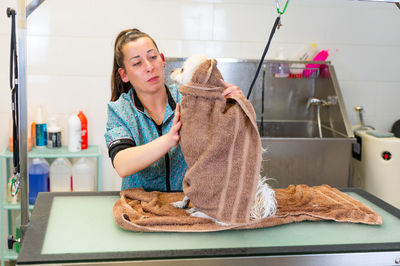 Pet groomer grooming dog at shop