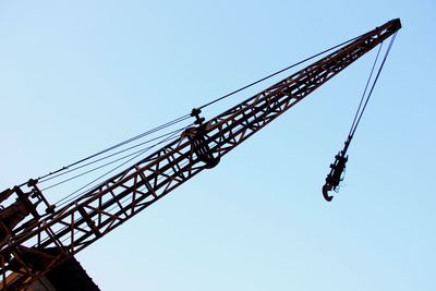 Low angle view of crane against clear sky