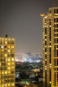 Illuminated buildings against sky at night