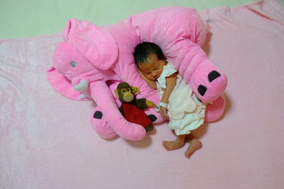 High angle view of baby with stuffed toy on bed