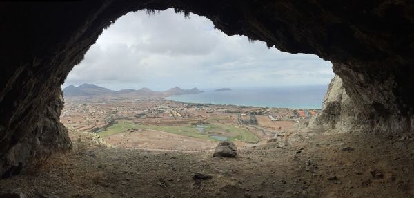 Panoramic view sea seen through rock formation against sky