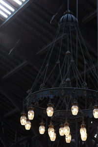 Low angle view of illuminated chandelier hanging from ceiling