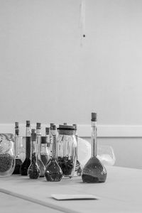 Close-up of bottles on table against wall at home