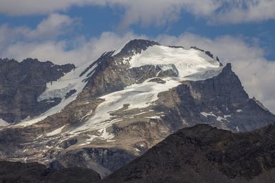 Scenic view of mountains against cloudy sky