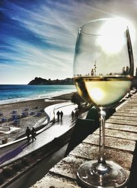 People on table by sea against sky during sunset