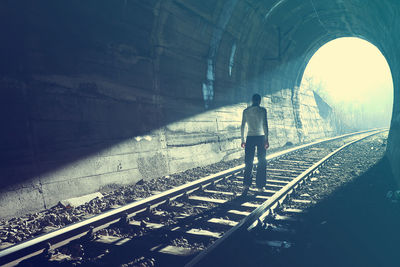 Rear view of person walking in tunnel