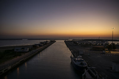 Boats moored at harbor during sunset