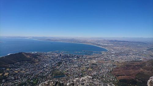 Aerial view of city buildings against blue sky