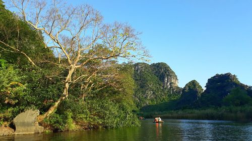 Scenic view of river and mountains against clear sky