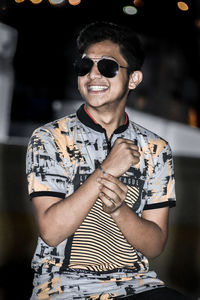 Portrait of young man wearing sunglasses standing outdoors