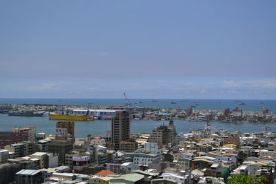 High angle view of buildings by sea against sky