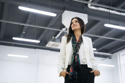 Portrait of young woman standing in factory